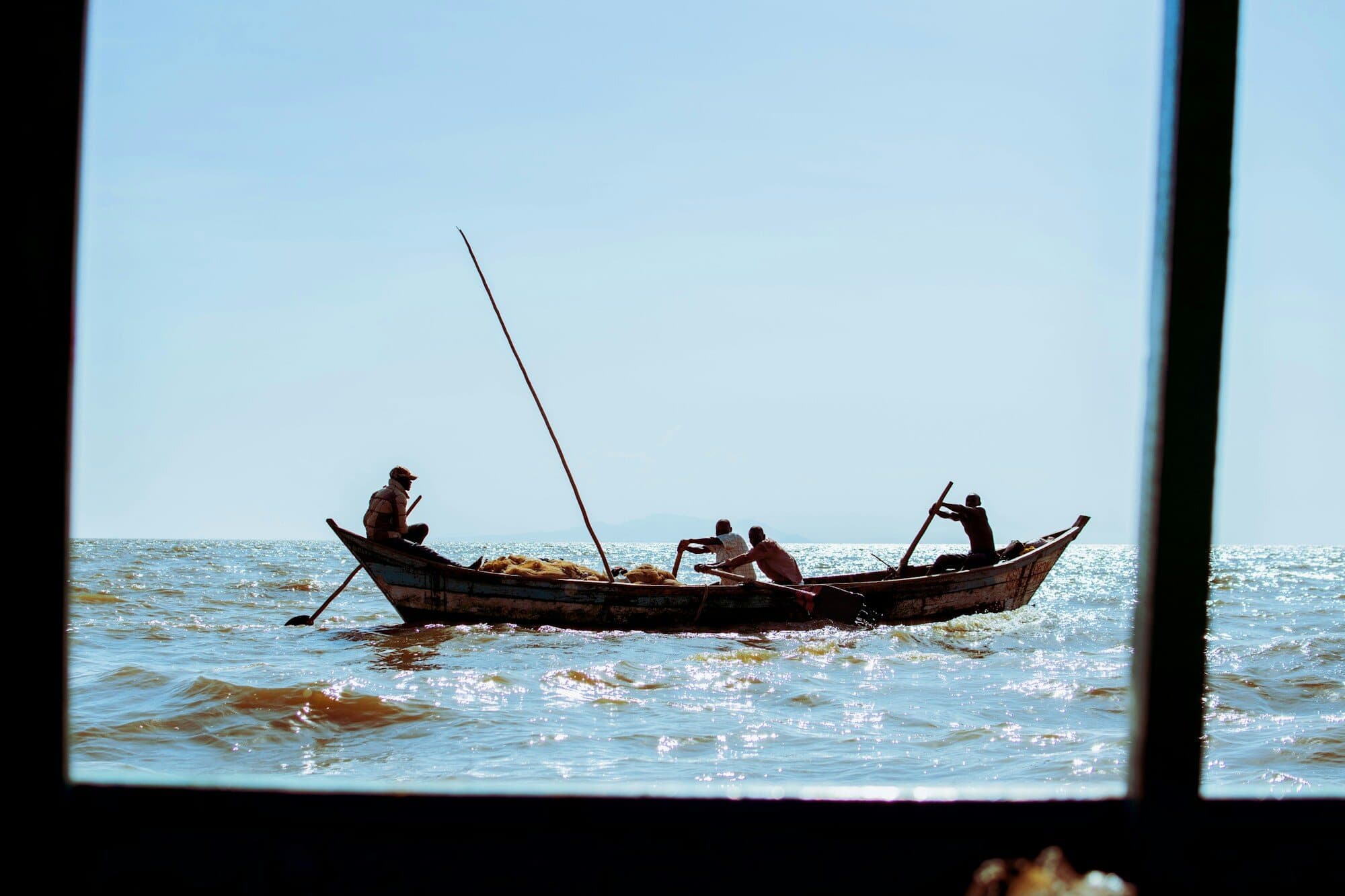 Fishermen rowing a wooden boat on Lake Victoria near Kisumu